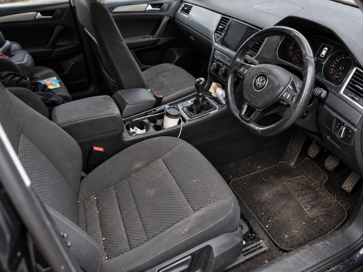 Interior before cleaning, showing everyday dirt on the seats and cabin surfaces